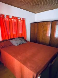 1 dormitorio con 1 cama con cortinas rojas en Casa Tito en Tunuyán