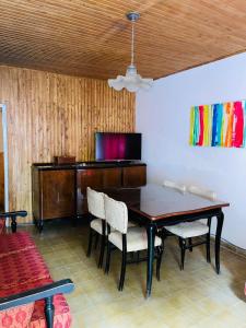 comedor con mesa, sillas y TV en Casa Tito en Tunuyán