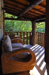 a wooden porch with a bed on a deck at Quinta das Bollótâs in Travassós
