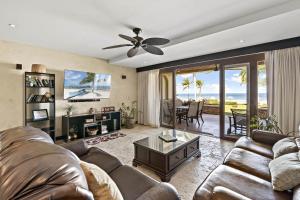 a living room with a couch and a ceiling fan at Luxury beachfront unit in Flamingo right in front of the waves in Playa Flamingo