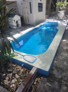 a swimming pool in a yard next to a house at Cabaña para disfrutar en cualquier ocasión. in Burzaco