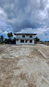 biały budynek z palmami przed nim w obiekcie Mead Road Homestay Tours & Transfers Deluxe Flat 2 Bedroom w mieście Suva