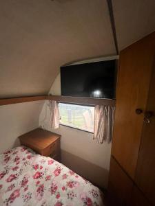 a small bedroom with a bed and a window at Trailer Oasis in Lavras Novas