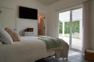 西米谷Cozy Family Hideaway, sleeps 8, 4 tv's yard, shops的卧室里有一张床，墙上有一台电视