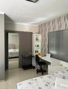ein Schlafzimmer mit einem Schreibtisch und ein Schlafzimmer mit einem Bett in der Unterkunft Loft com linda vista na Rota do Enxaimel in Pomerode