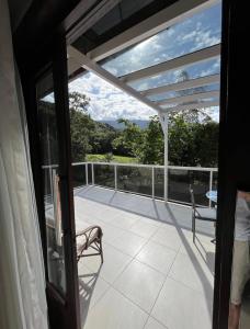 einen Balkon mit Blick auf eine Terrasse mit 2 Stühlen in der Unterkunft Loft com linda vista na Rota do Enxaimel in Pomerode