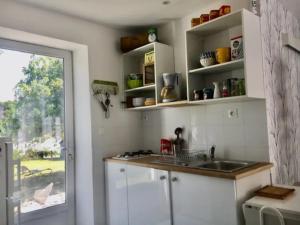 kuchnia z białymi szafkami, umywalką i oknem w obiekcie Romantic holiday home in Précy with garden w mieście Précy