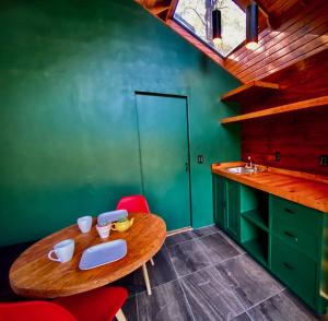 a kitchen with a wooden table and a green wall at Casa Alfeñique in Villa del Carbón