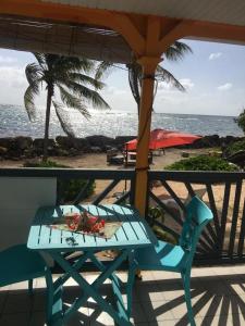 una mesa azul y una silla en un balcón con vistas al océano en Résidence Nature Ocean - M&P Concept, en Cadet