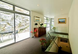 a living room with a staircase and a large window at Spectacular Panoramic 5Bedroom Lakeview in Queenstown