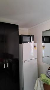 uma cozinha com um frigorífico branco e um espelho em Meadroad homestay tours & transfers Studio Flat em Suva