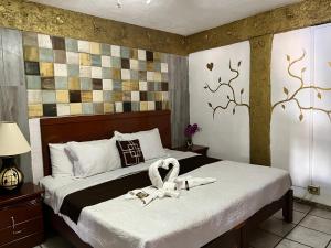ein Schlafzimmer mit zwei Betten mit Schwänen darauf in der Unterkunft HOTEL CASONA DE LAS AVES in Guanajuato