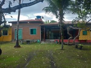 una casa con una palmera delante de ella en Casa Guaiú, en Santa Cruz Cabrália