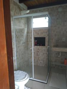 y baño con ducha, aseo y lavamanos. en Casa Guaiú, en Santa Cruz Cabrália