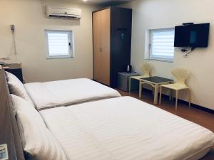 a hospital room with two beds and a tv at Lai Chi Te Hotel in Tainan