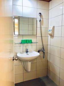 ein Bad mit einem Waschbecken und einem Spiegel in der Unterkunft Lai Chi Te Hotel in Tainan