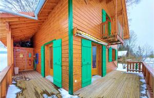 ein Holzgebäude mit grünen Türen und einem Balkon in der Unterkunft 3 Bedroom Pet Friendly Home In La Longeville in La Longeville