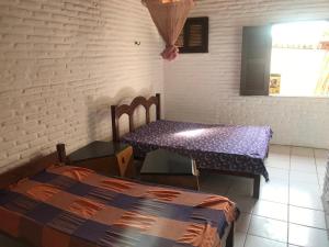 een kamer met een tafel, een bed en een raam bij Casa de Praia, na Praia do Presídio in Aquiraz
