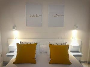 een slaapkamer met 2 gele kussens op een bed bij CONCEPCIÓN SUITE PLAZA in La Laguna