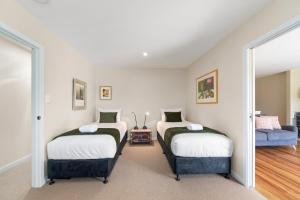 a room with two beds and a couch at Great Lake Getaway - Taupo in Taupo