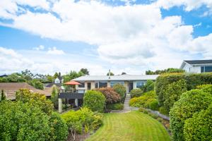 a house with a garden and a patio at Great Lake Getaway - Taupo in Taupo