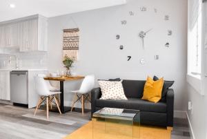 ein Wohnzimmer mit einem schwarzen Sofa und einem Tisch in der Unterkunft Modern 1br Home Full Kitchen Smarttv in Calgary