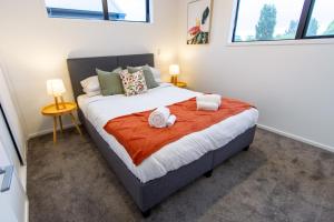 1 dormitorio con 1 cama grande y 2 toallas. en Tranquil 2 bed townhouse w/carparking, en Christchurch