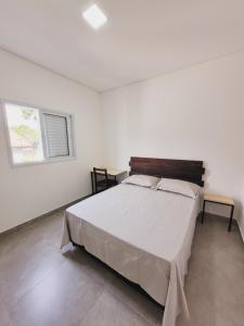 um quarto com uma cama grande num quarto branco em Mimos Hospedagem em São Paulo