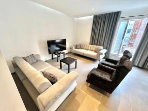 a living room with two couches and a television at Brand-new apartments in the heart of Brussels in Brussels