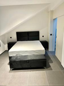 a bed with a black bed frame in a room at Brand-new apartments in the heart of Brussels in Brussels