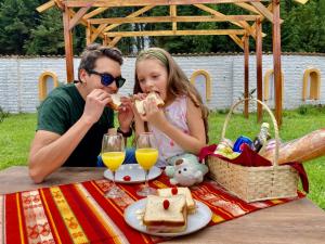 a man and a girl eating food at a picnic table at Hostería El Troje Experience in Riobamba +55 photos