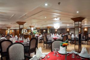 uma sala de jantar com mesas e cadeiras num restaurante em Nile Cruise 3 nights From Aswan to Luxor Every Friday, Monday and Wednesday with tours em Jazīrat al ‘Awwāmīyah