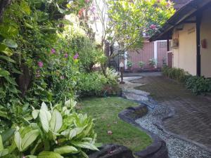 a garden with a cobblestone path in a yard at The Ellen Hotel by ecommerceloka in Senggigi
