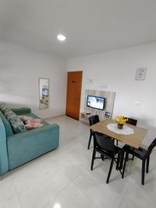 a living room with a couch and a table at Flat Getsêmani Olímpia a 10min do Thermas dos Laranjais in Olímpia