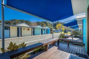 a bench on a deck in front of a building at Kaiteriteri Reserve Cabins in Kaiteriteri