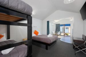 a bedroom with two bunk beds and a living room at Kaiteriteri Reserve Cabins in Kaiteriteri