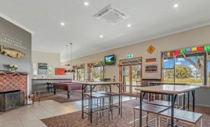 a room with tables and a fireplace in a classroom at Falcon Hotel Motel in Kanyapella