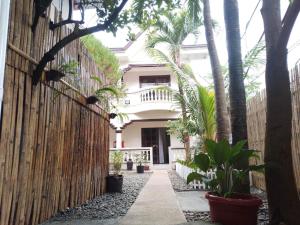 a walkway in front of a house with palm trees at Tresha Lance Apartelle in Boracay