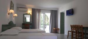 una camera con due letti e una grande finestra di Andromeda Hotel Apartments a Città di Kos