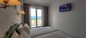 a living room with a couch and a large window at Andromeda Hotel Apartments in Kos Town