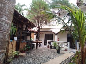 a courtyard of a house with a table and trees at Tresha Lance Apartelle in Boracay