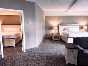 une chambre d'hôtel avec deux lits et un canapé dans l'établissement The Georgian Resort, à Lake George