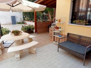 een patio met een tafel, banken en een parasol bij Villa Marchele in Carini