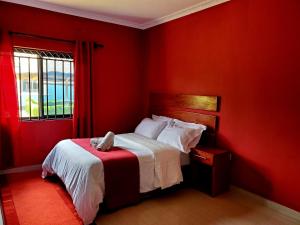a red bedroom with a bed with a dog laying on it at Sweet Retreat in Lusaka +21 photos