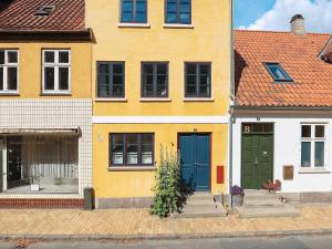 una casa amarilla con puertas azules en una calle en Holiday home Faaborg XXXII en Fåborg