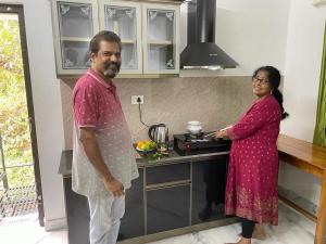 Ein Mann und eine Frau stehen in einer Küche in der Unterkunft Jayuz Homestay & Foodies in Kozhikode