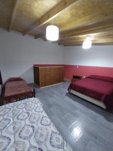 1 dormitorio con 2 camas en una habitación con sábanas rojas en Casa de Andrea departamento en Esquel