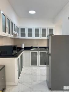 una cucina con armadi bianchi e frigorifero in acciaio inossidabile di Apartment Av. Republica de Colombia US embassy a Santo Domingo
