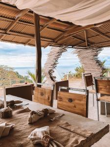 einen Tisch und Stühle unter einem Zelt mit Meerblick in der Unterkunft Casa Lamia in Manuel Antonio
