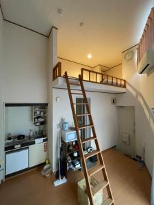 a room with a loft bed and a kitchen at 大宮溫馨小屋 in Saitama